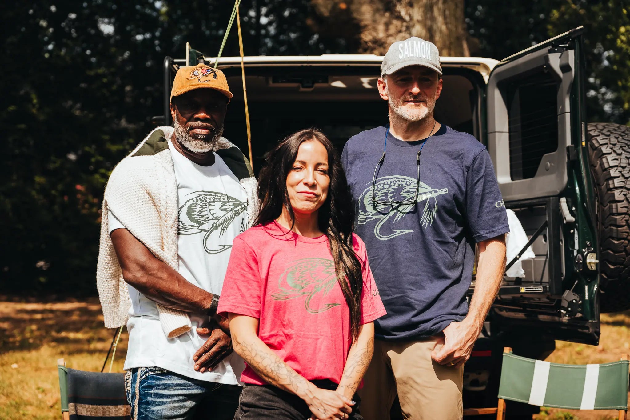 Three anglers in Gillies Gear tees and caps in front of a Land Rover Defender
